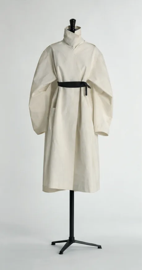 Un manteau écru ceinturé sur un mannequin