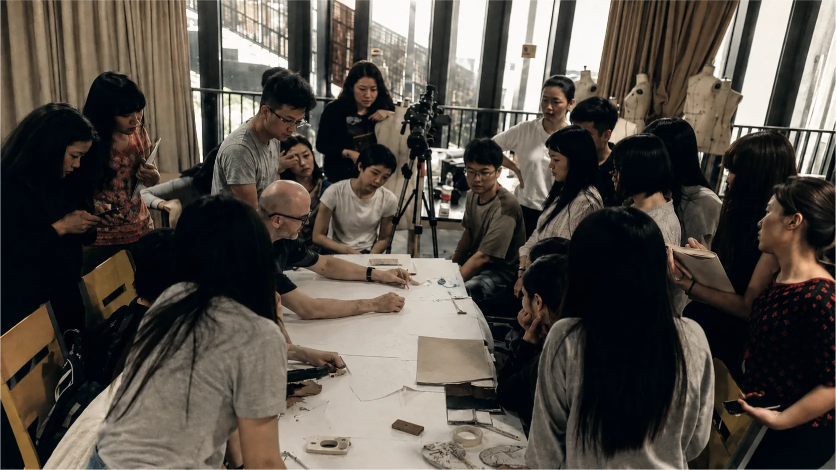Dominique Pellen among some twenty students, around a cutting table