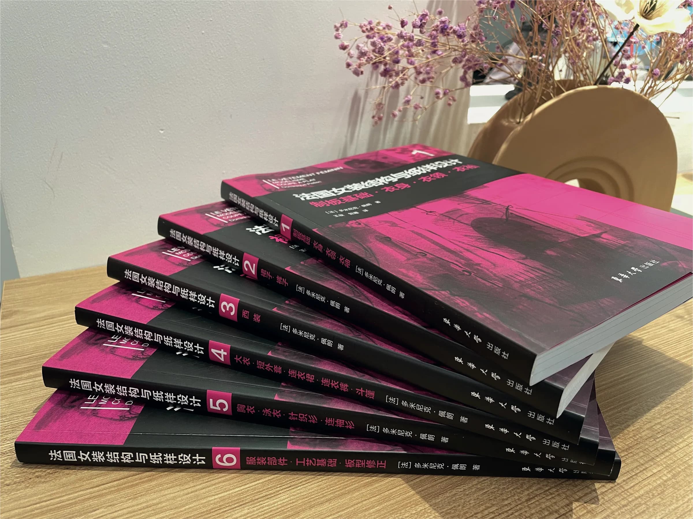 The six volumes of the Chinese edition, with their magenta covers, fanned out on a table