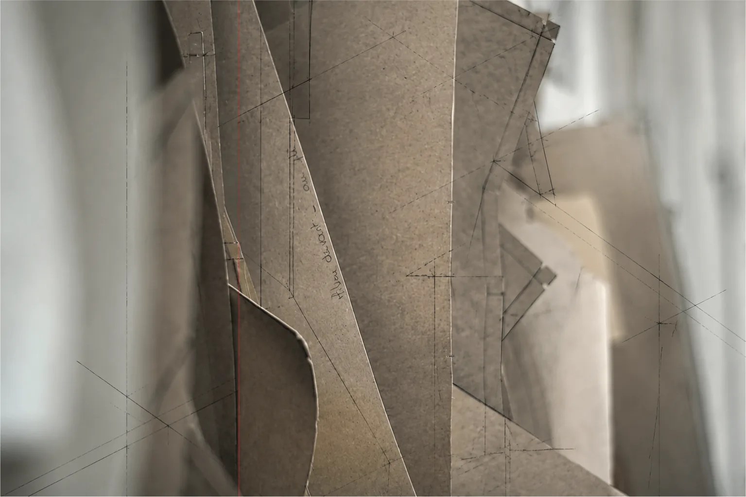 Kraft cardboard patterns drafted in pencil, standing in the atelier